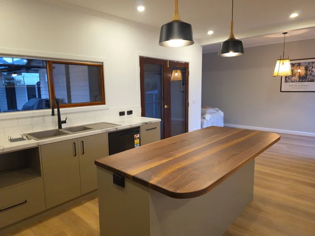 Renovated kitchen with a solid timber island benchtop and pendant lighting
